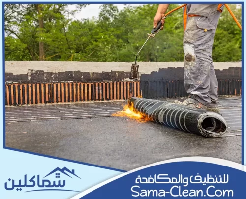 عامل يقوم بتركيب لفائف عزل مائي باستخدام النار لحماية الأسطح من تسرب المياه والرطوبة.